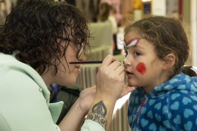 une femme maquille une petite fille, elle lui fait un point sur le nez - Agrandir l'image 9 sur 26, fenêtre modale