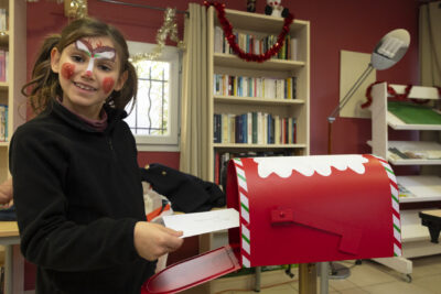 photo d'une jeune fille maquillée qui dépose une lettre dans une boîte à lettres aux couleurs de Noël - Agrandir l'image 10 sur 26, fenêtre modale