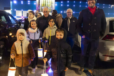 photo des enfants devant qui marchent avec les lampions dans la main, on voit la façade de l'Escale éclairée derrière - Agrandir l'image 15 sur 20, fenêtre modale