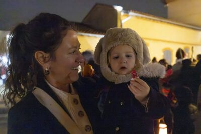 une femme tient un enfant dans ses bras, l'enfant regardent un bonbon qu'il tient dans sa main - Agrandir l'image 10 sur 20, fenêtre modale