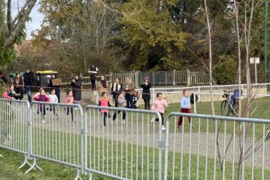 photo de la course, les enfants courent sur la piste, on voit les grilles de sécurité