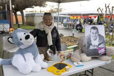 photo d'une femme derrière son stand au profit des Restos du cœur - Agrandir l'image 11 sur 12, fenêtre modale
