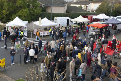 photo des personnes rassemblées autour du Noël sur la place et du début du marché derrière - Agrandir l'image 2 sur 12, fenêtre modale