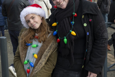une femme et une jeune fille sourient à l'objectif, la tête penchée, un bonnet de Noël sur la tête et une fausse guirlande lumineuse en collier - Agrandir l'image 4 sur 12, fenêtre modale